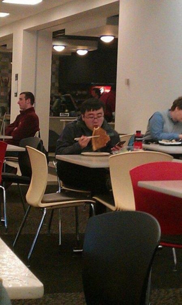 This kid eating pizza with chopsticks.